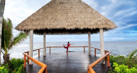 woman doing yoga pose on overwater deck