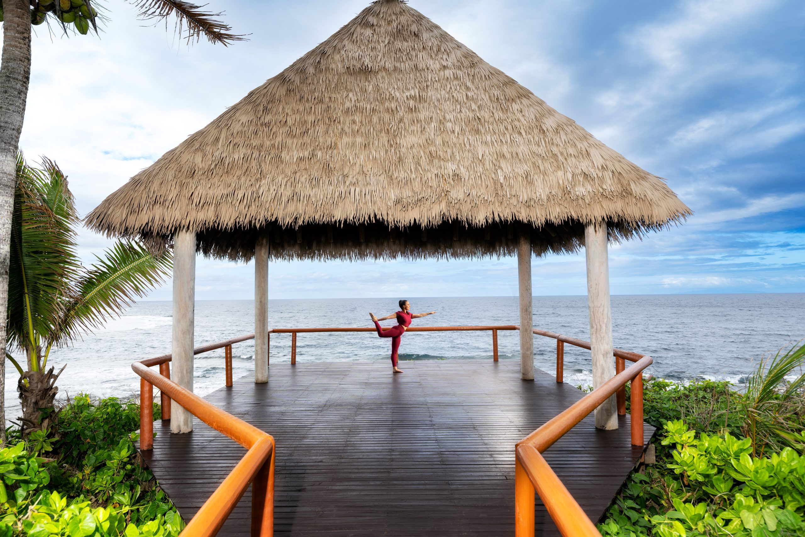 woman doing yoga pose on overwater deck